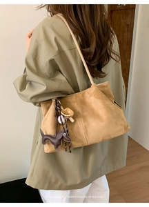 Detail of camel suede tote bag with a dachshund charm and a minimalist retro vibe