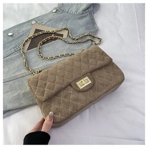 Macro shot of brown quilted suede texture and golden metal chain strap detail