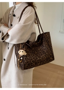 Detail of leopard print tote bag with plush bear charm and pearls in a retro style