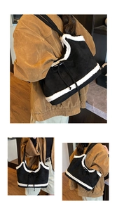 Detailed view of large black faux suede tote bag with white faux shearling trim and bow tie