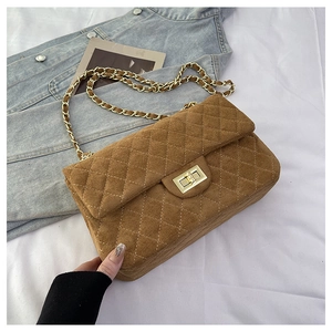 Close-up of caramel brown quilted suede chain bag with metal turn-lock and chain strap