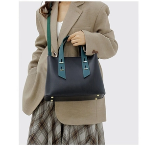 Modern black pebbled tote with green handles shown on model for a work-ready style