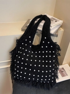 Black knit tote bag with white pearl accents and long fringe details in a chic style