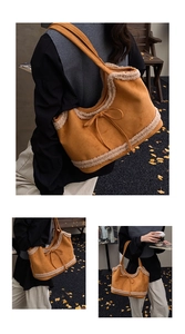 Detail of a large suede tote bag with faux shearling trim and decorative bow accent