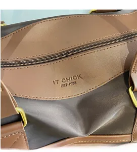 Detail of smooth metal zipper and gold D-ring hardware on fabric and leather handbag