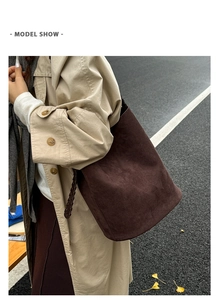 Détail du sac seau en daim marron chocolat avec une bandoulière tissée élégante