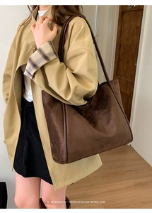 Detailed view of the brown suede tote bag with leather piping and minimalist retro vibe