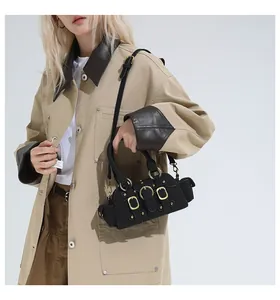 Dettaglio di una borsa nera stile moto con fibbie dorate e rivetti indossata da una modella