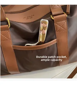 Detail of durable side pocket on large brown nylon travel bag with leather trim