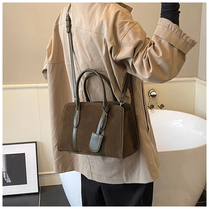 Détail du sac Boston vintage en daim marron avec garniture en cuir vert foncé