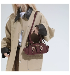 Dettaglio della mini borsa bordeaux con fibbie metalliche e texture opaca da vicino