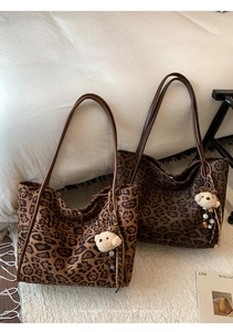 Detail of vintage leopard print tote bag with leather straps and plush bear charm