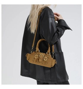 Borsa tote retrò marrone con fibbie dorate indossata da una modella in giacca di pelle