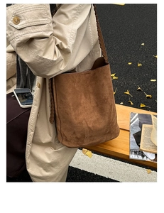Détail du sac seau en daim marron foncé avec des lanières tressées au style bohème chic