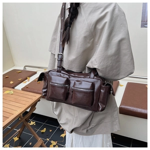 Detail view of brown vintage multi-pocket shoulder bag with adjustable metal buckle strap