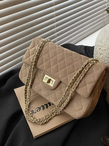 Brown quilted suede chain shoulder bag with gold turn-lock closure on lifestyle background
