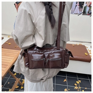 Detail of dark brown faux leather shoulder bag with multiple utility pockets