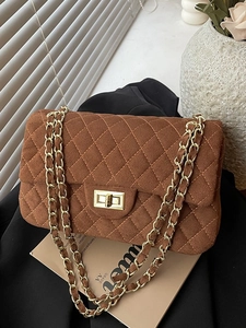 Chic dark brown quilted shoulder bag with golden chain strap and suede finish in natural light