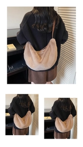 Detail of plush crescent dumpling bag featuring elegant brown leather shoulder straps