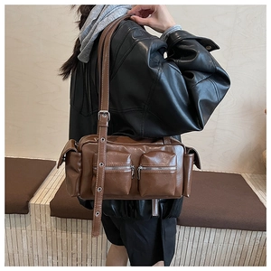 Macro detail of brown PU leather shoulder bag with multi-pockets and silver zippers