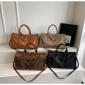 Collection of large travel duffel bags in tan, khaki, brown, and black nylon fabrics