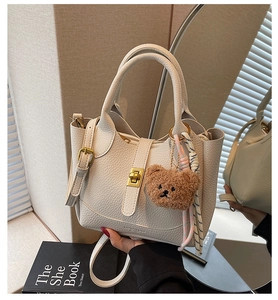 Détail du sac seau en cuir grainé avec breloque ours et foulard en soie décoratif