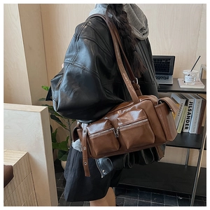 Detail of vintage brown shoulder bag with multiple functional pockets and glossy finish