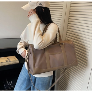 Brown travel tote bag on a person, showing its large capacity and stylish side design