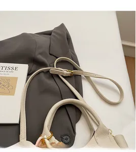 Détail du sac en cuir litchi blanc avec boucle dorée et bandoulière réglable