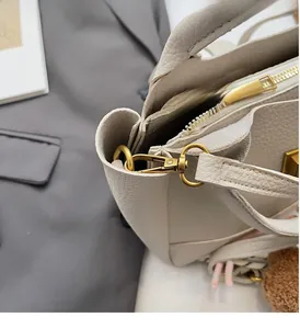 Détail du sac seau en cuir grainé avec finitions métalliques dorées haut de gamme et fermeture