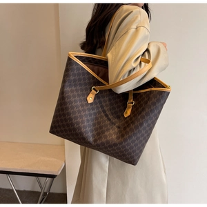 Detail view of large tote bag with geometric M-pattern and long shoulder straps