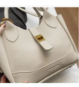 Détail du sac seau en cuir litchi blanc crème avec boucle dorée et foulard en soie décoratif
