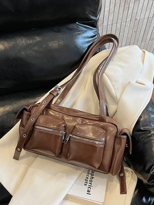 Brown leather underarm bag with dual front zipper pockets and adjustable eyelet strap