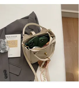 Détails de l'intérieur spacieux du sac seau avec fermoir doré et charme d'ours peluche