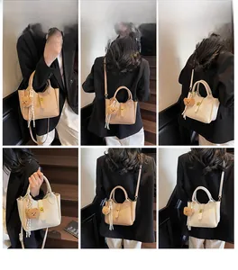 Vues détaillées des sacs seaux beiges et crème avec fermoir rotatif et charm ourson doux
