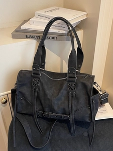 Sac Boston rétro noir avec lacets croisés et rivets sur un tissu effet daim texturé