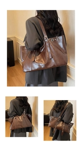 Detail of a dark brown large capacity tote bag with vintage leather texture and silver rings