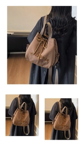 Detail of khaki canvas drawstring backpack with YOUJI BEAR embroidery and side pocket