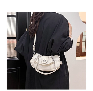 Close-up of minimalist off-white moon bag with silver chain and metal clasp