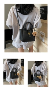Détail du sac seau en cuir litchi avec fermoir doré et pendentif ours en peluche
