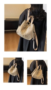 Detail of beige canvas drawstring backpack featuring embroidered logo and side elastic pockets
