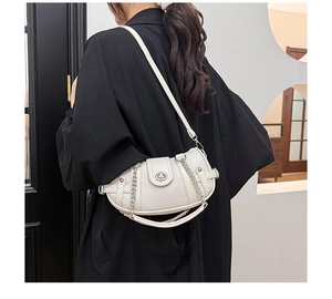 Detail view of the cream-white lychee grain leather handbag with stylish metal chain link