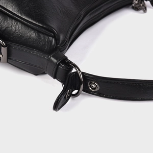 Detail of premium black leather shoulder bag with dark gunmetal hardware and stitching