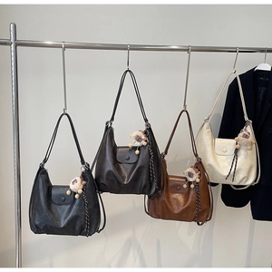 Dettaglio di grandi borse hobo in pelle PU in quattro colori con ciondoli a forma di pecora
