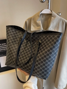 Fashionable black tote bag with geometric print and leather straps for commuting