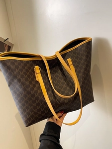 Large tote bag with brown monogram pattern and yellow handles for office commuting