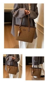 Close-up of brown suede tote bag with leather trim and decorative beaded tassel charm