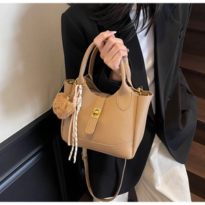 Détail du sac seau en cuir litchi kaki avec fermoir doré et pendentif ours mignon