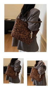 Close-up of leopard print tote bag with beaded charm accessory on brown leather strap