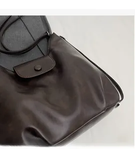 Dettaglio della consistenza della morbida pelle PU vintage e patta magnetica della borsa